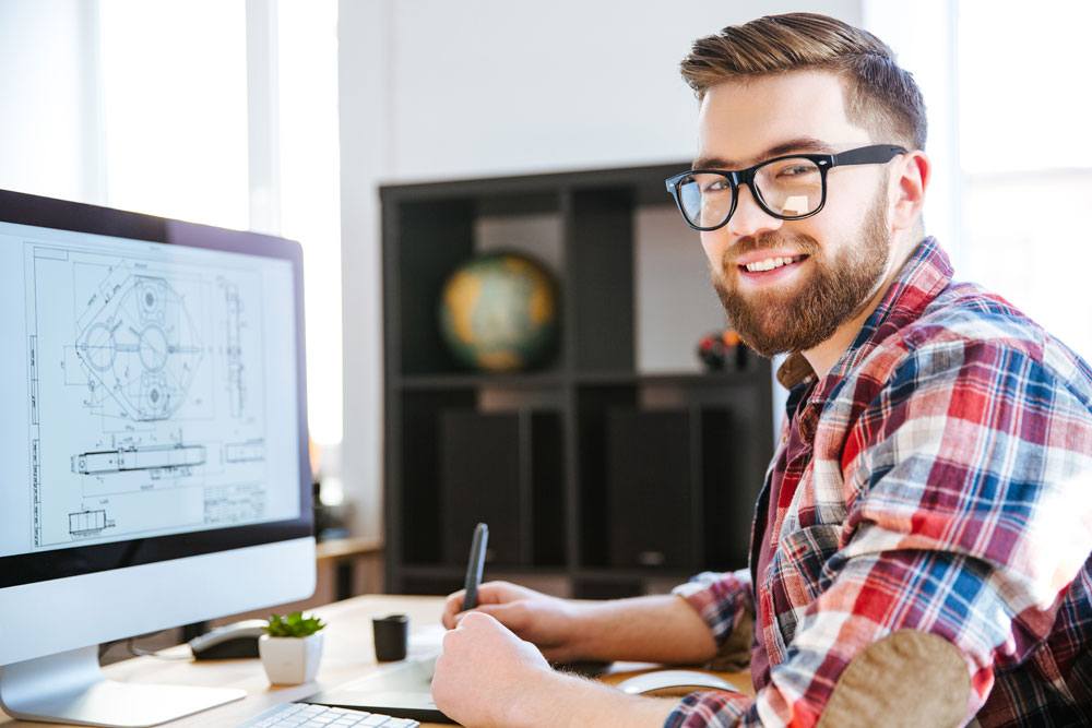 Electrical estimator reviews blueprints on his computer