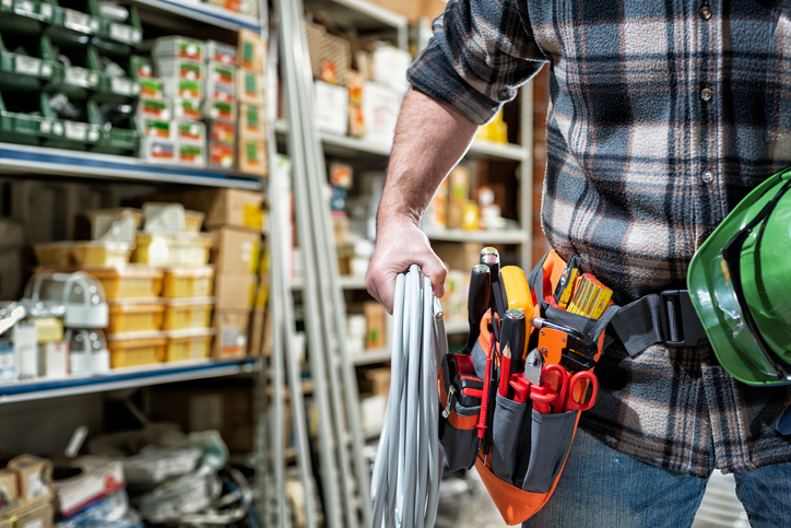 Electrician in the store of electrical components. Electricity. Electrical contractor with electrical materials